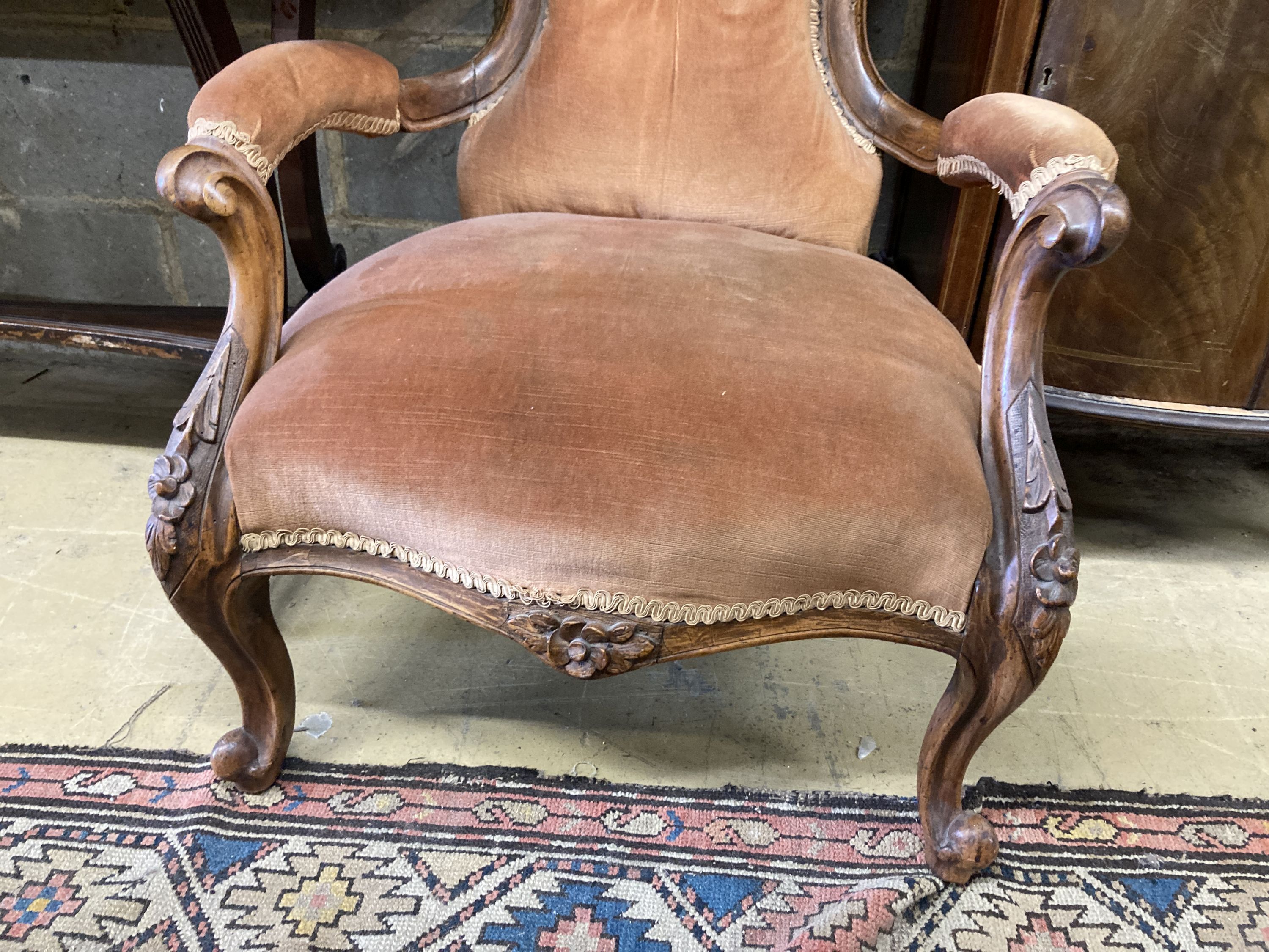 A Victorian walnut spoonback open armchair